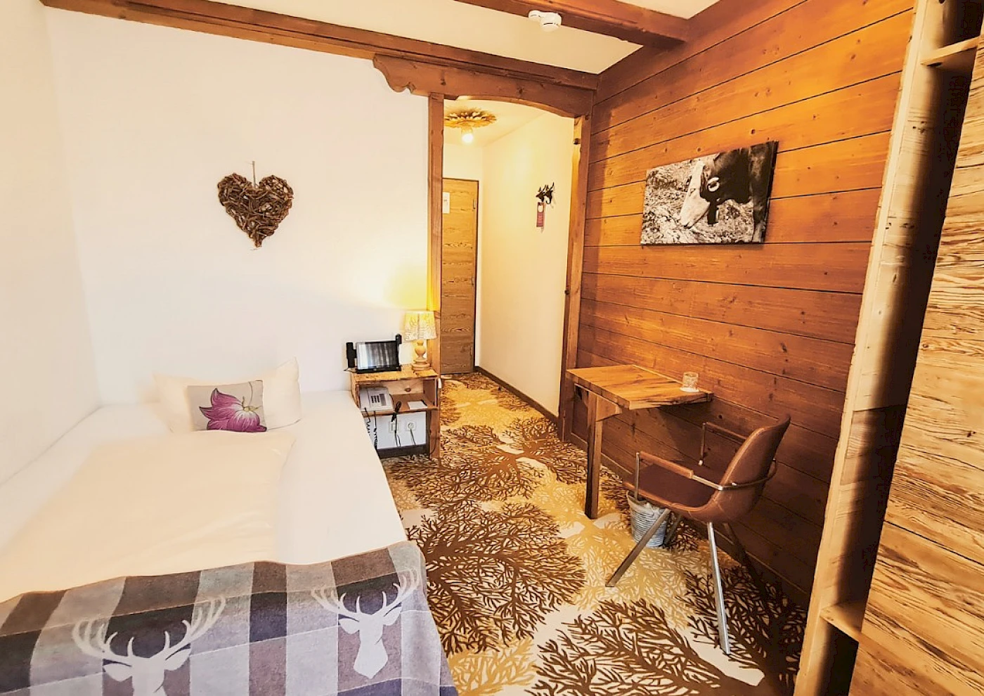 Übersicht vom Einzelzimmer mit Bett, TV & liebevollen Details