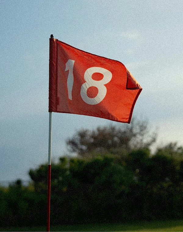 18-er Fahne auf Golfplatz weht im Wind