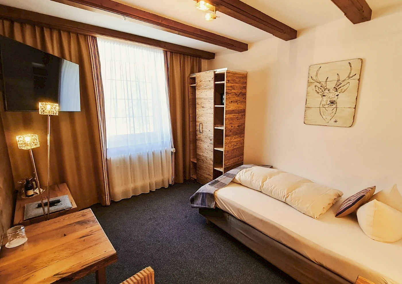 Übersicht vom Einzelzimmer mit Bett, TV & bunten Details