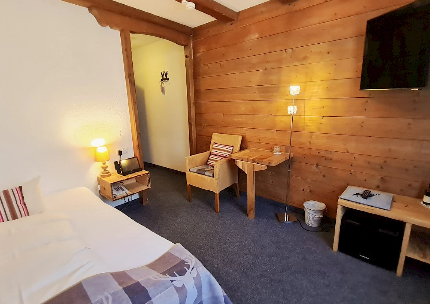 Übersicht vom Einzelzimmer mit Bett, TV & bunten Details