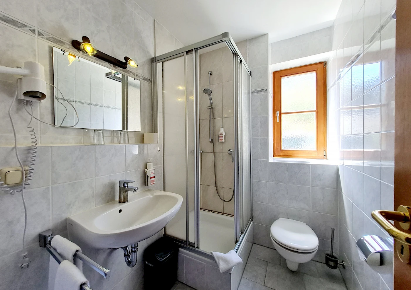 Blick von oben auf das Ufer des Schliersees und das Apartmenthaus 