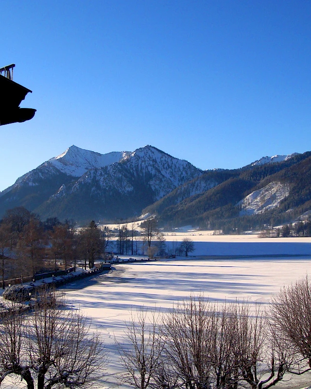 Frau liest ein Magazin bei einem kühlen Drink in der Sonne, auf gemütlichen Loungemöbeln am Schliersee